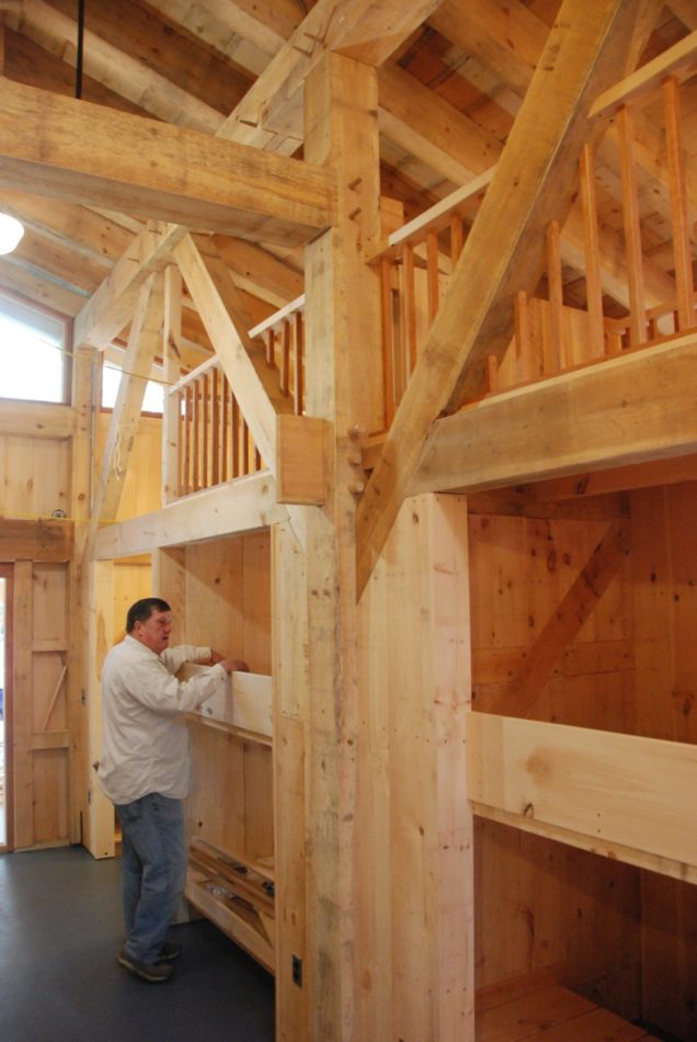 Worker inspects bunkbed in timber frame bunkhouse at Mountain Lodge