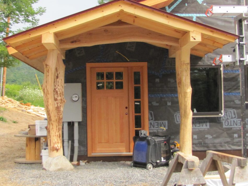 Covered entry on timber frame home timber scribed to rock
