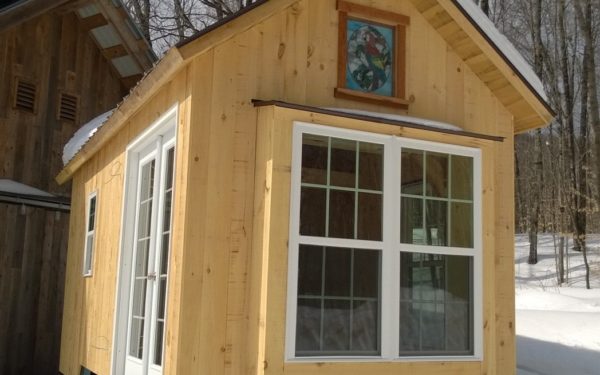 Tiny timber frame from the outside. Sweet bump out window, framed stain glass, french doors, pine siding.