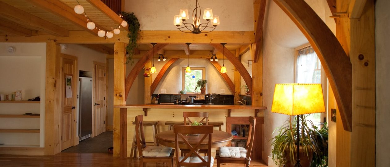 A small dining room in a timber frame house with curved cherry braces