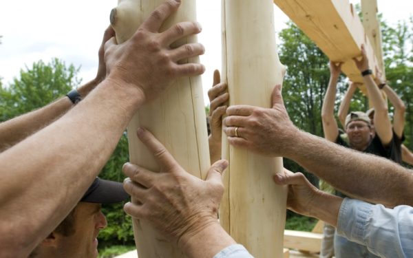 group of people participating in a community timber frame raising