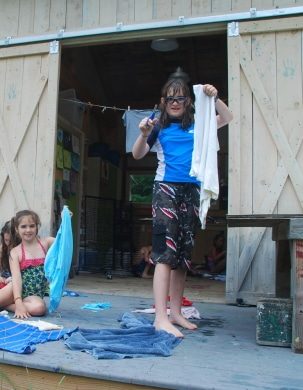 Arts and crafts happen on the porch of a camp barn