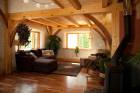 Living room in a timber frame house with exposed beams and curving braces