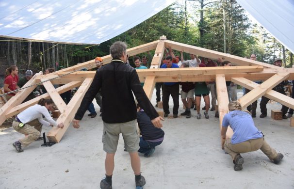 A section of a timber frame getting raised in the air