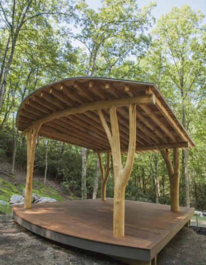 four forked trees hold up a fanned out roof in an amphitheater in north carolina