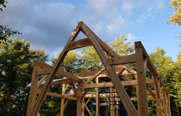 A cruck shaped timber frame is raised in Vermont