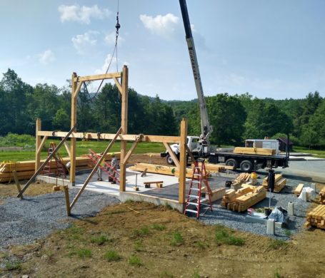First cross section of a timber frame horse barn is raised in Lyme, NH.
