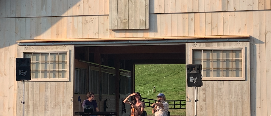 A band tunes up in front of a new timber frame barn