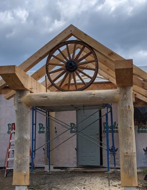 A round log timber frame with an inset wagon wheel
