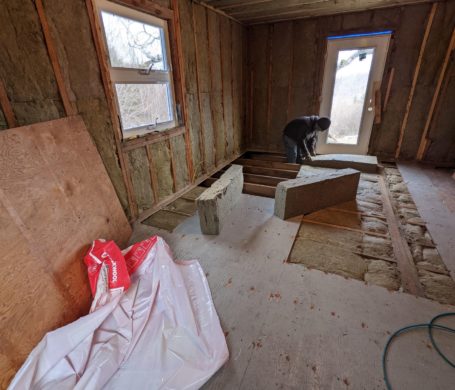 A home renovation job in the work - exposed insulation in the floor and walls, subfloor partially down
