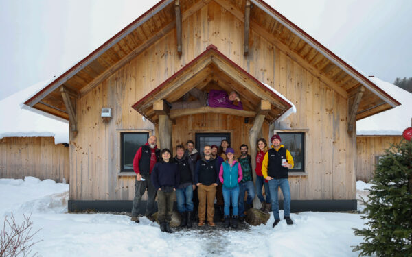 The worker owned cooperative members of TimberHomes Vermont standng in front of their Montpelier wood shop