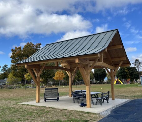 Beautiful timber framed pavilion in Vermont with a blue sky and white clouds