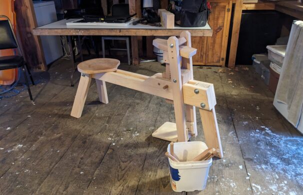 A wooden shavehorse, which looks roughly like the shape of a horse, and is used by woodworkers to work on material while sitting down, and clamping the material with a foot pedal.